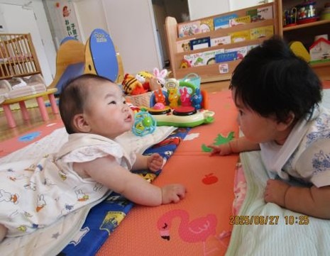 写真:あかちゃん2人が会話をするように顔を見合わせる様子