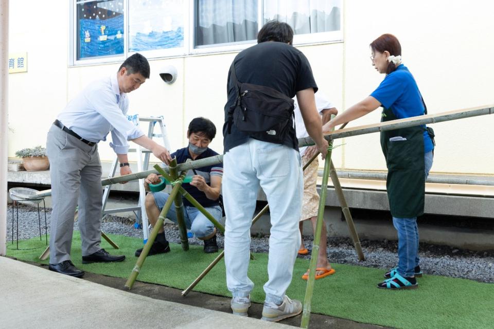 流しそうめん用の竹を組み立てている写真