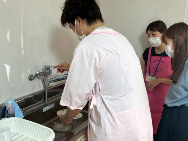 妊婦ジャケットを着用して家事の シュミレーションをしているパパの画像